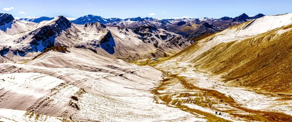 Trail leading to Vinicunca with hikers and colorful Andean landscapes, part of the comparison: Vinicunca vs. Pallay Punchu — Which Rainbow Mountain trail is right for you