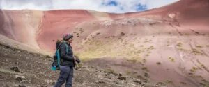 Hikers walking along the colorful slopes of Rainbow Mountain in Peru, exploring its vibrant terrain and high-altitude scenery